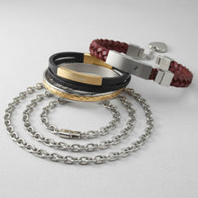 Collection of cremation bracelets and a chain on a light gray background